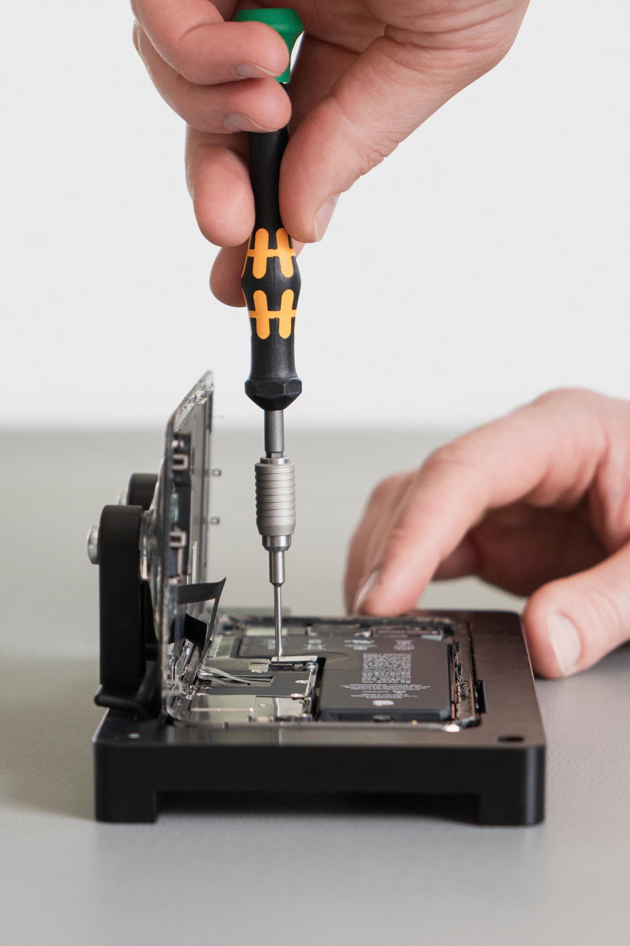 Szétnyitott iPhone javítása precíziós csavarhúzóval